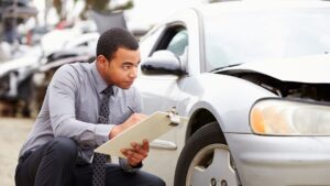 A man inspecting a vehicle with a checklist in hand.