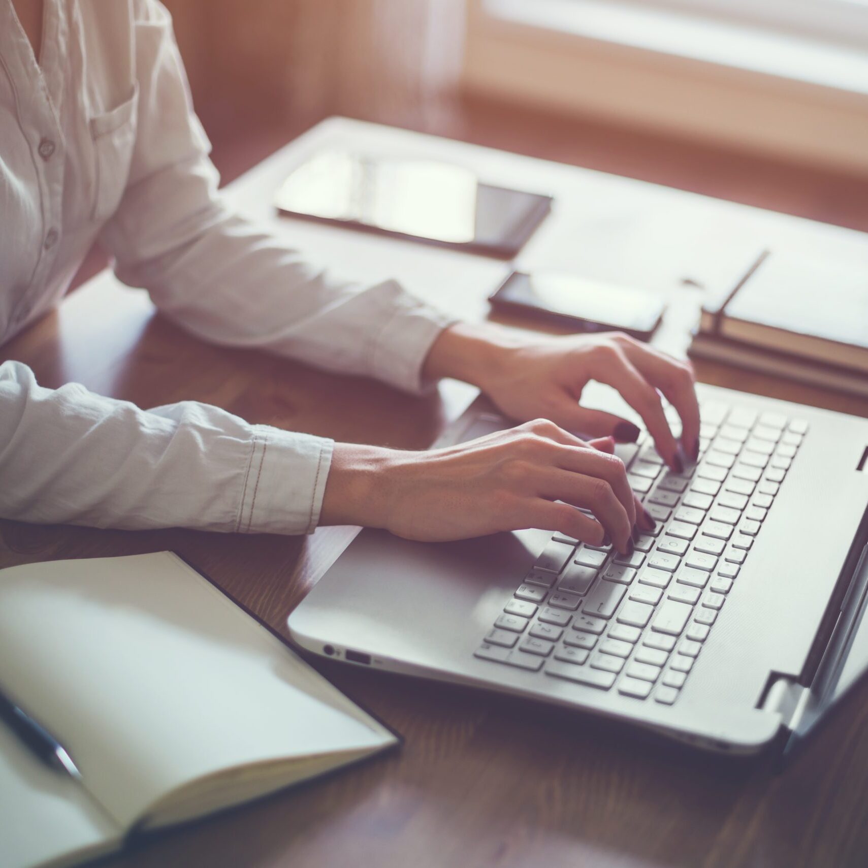 Woman working in home office hand on keyboard close up.